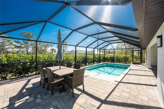 outdoor pool with a patio area and glass enclosure