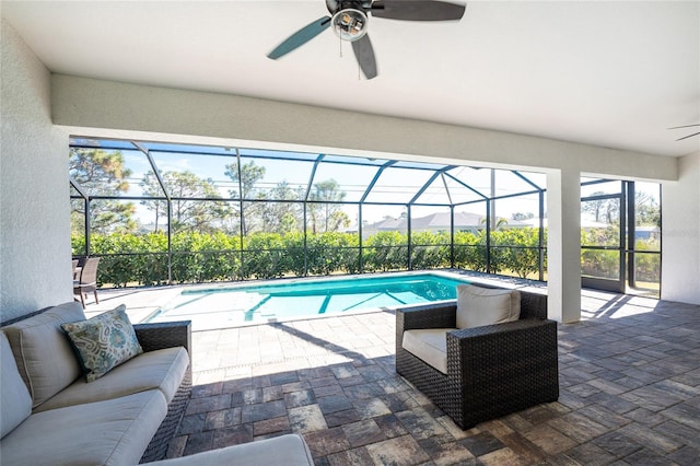 outdoor pool featuring a patio area, an outdoor living space, glass enclosure, and a ceiling fan