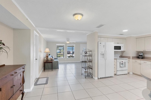 kitchen featuring light tile patterned floors, visible vents, open floor plan, white cabinets, and white appliances