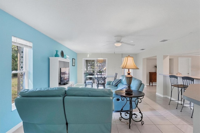 living room with light tile patterned floors, a ceiling fan, visible vents, and baseboards