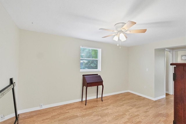 unfurnished room featuring light wood-style floors, baseboards, and a ceiling fan