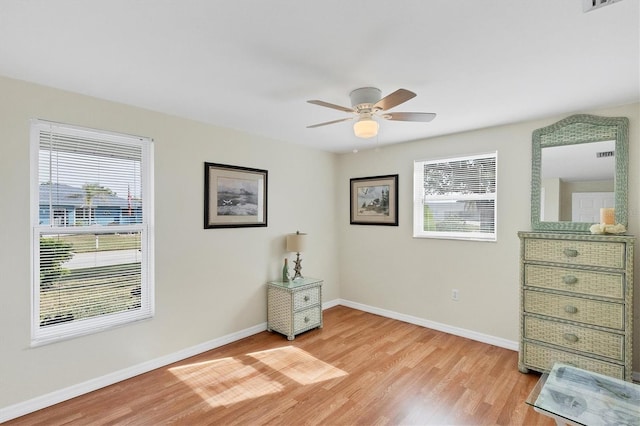 interior space featuring baseboards, a ceiling fan, and light wood-style floors