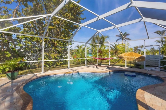 outdoor pool with a patio area and glass enclosure