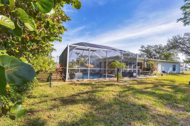 rear view of house with an outdoor pool, a patio area, a lawn, and a lanai