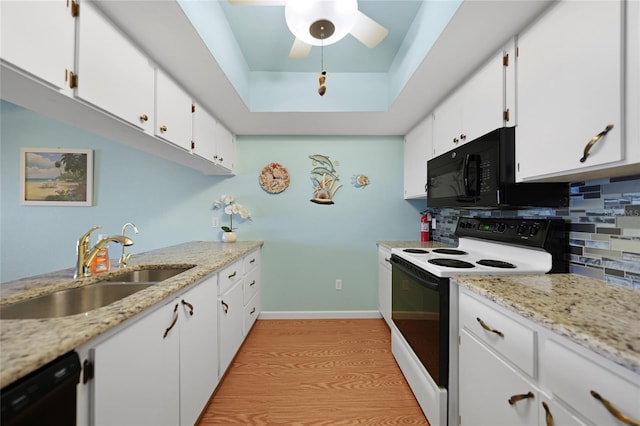 kitchen featuring sink, white cabinetry, tasteful backsplash, a tray ceiling, and black appliances