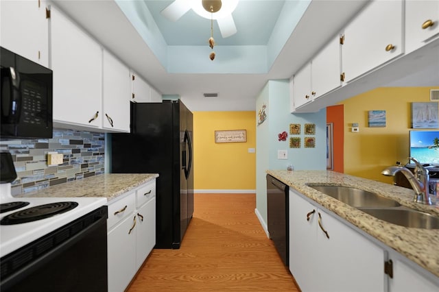 kitchen featuring sink, white cabinetry, tasteful backsplash, black appliances, and a raised ceiling