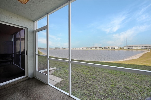 unfurnished sunroom featuring a water view