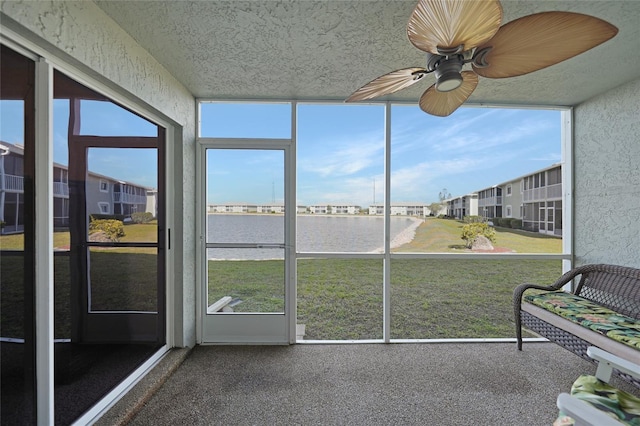 unfurnished sunroom with ceiling fan