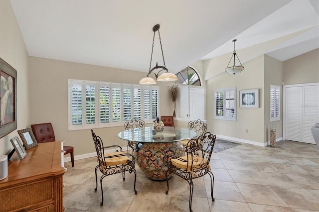 dining room featuring lofted ceiling, light tile patterned floors, and a healthy amount of sunlight