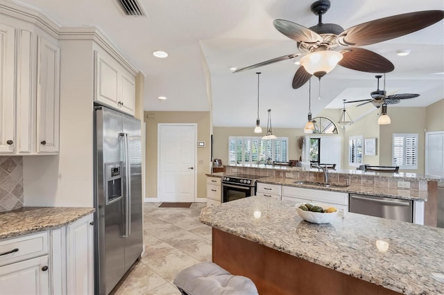 kitchen featuring light stone counters, stainless steel appliances, sink, and white cabinets