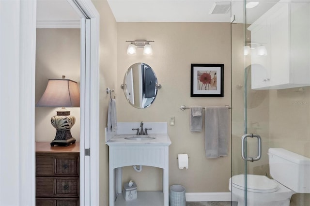 bathroom featuring vanity, a shower with shower door, and toilet