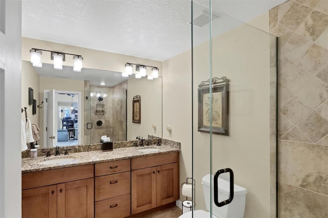 bathroom featuring walk in shower, vanity, toilet, and a textured ceiling