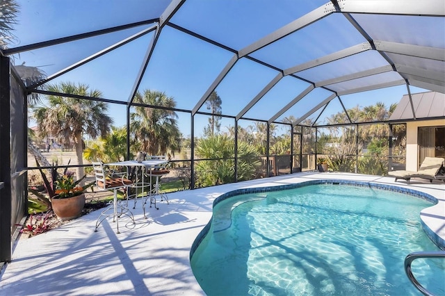 view of pool with glass enclosure and a patio area