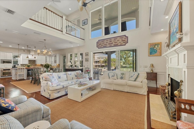 living room with hardwood / wood-style floors, ceiling fan with notable chandelier, and beverage cooler