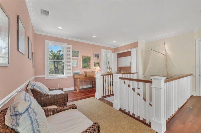 living area featuring wood-type flooring and ornamental molding