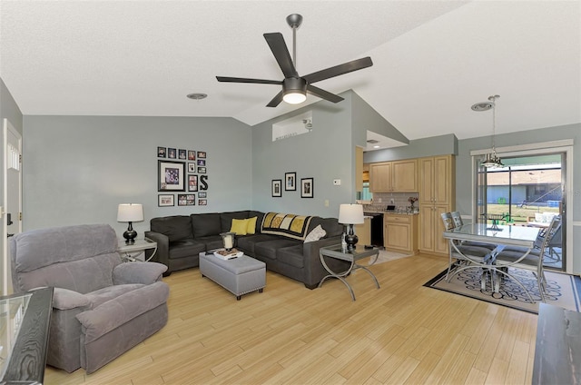 living room featuring ceiling fan, vaulted ceiling, and light hardwood / wood-style flooring