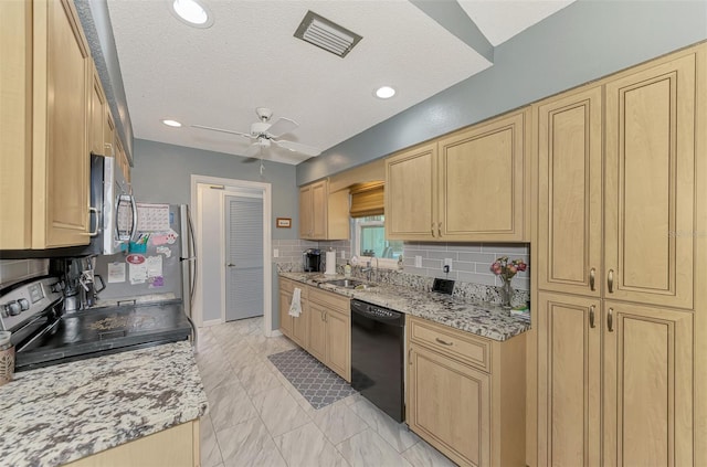 kitchen featuring light stone counters, appliances with stainless steel finishes, sink, and tasteful backsplash