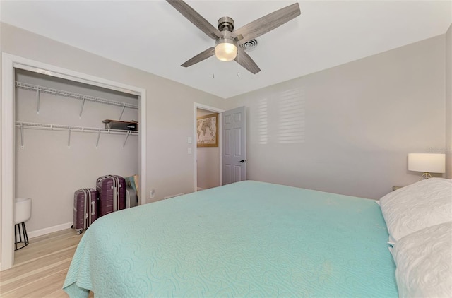 bedroom with ceiling fan, light hardwood / wood-style floors, and a closet