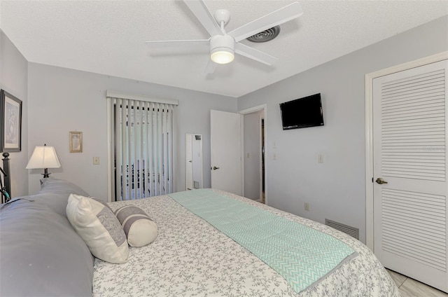 bedroom with ceiling fan, a closet, and a textured ceiling