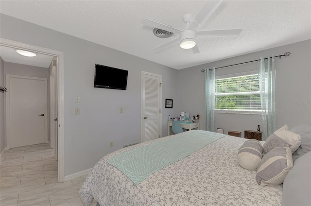 bedroom featuring ceiling fan and a textured ceiling