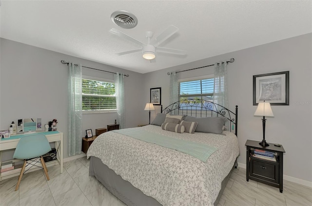 bedroom with ceiling fan and a textured ceiling