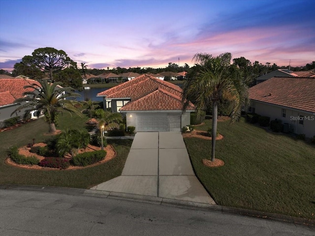 mediterranean / spanish-style home featuring a yard and a garage