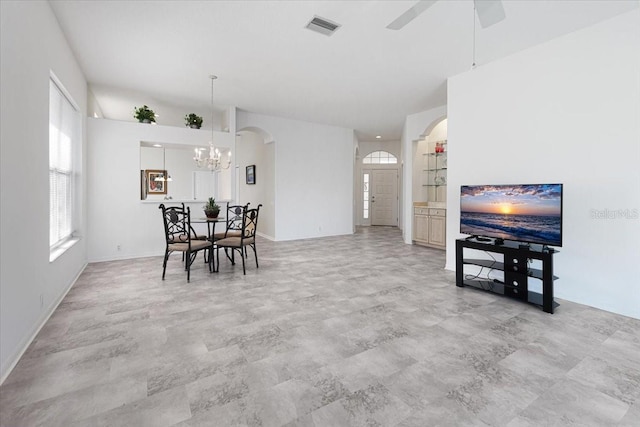 dining area featuring ceiling fan with notable chandelier