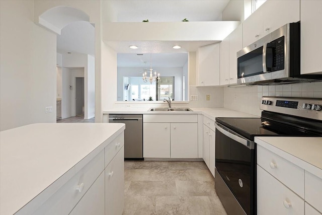 kitchen featuring sink, stainless steel appliances, hanging light fixtures, and white cabinets