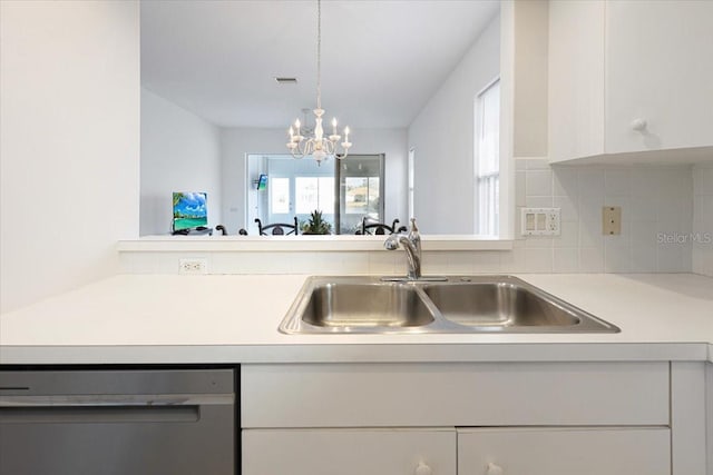 kitchen featuring white cabinetry, stainless steel dishwasher, sink, and hanging light fixtures