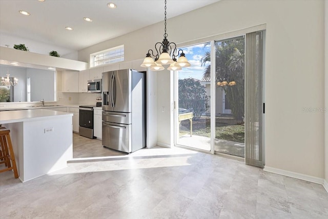 kitchen featuring white cabinetry, pendant lighting, appliances with stainless steel finishes, and a notable chandelier