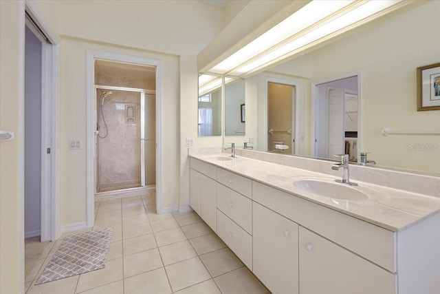 bathroom with a shower with door, vanity, and tile patterned flooring