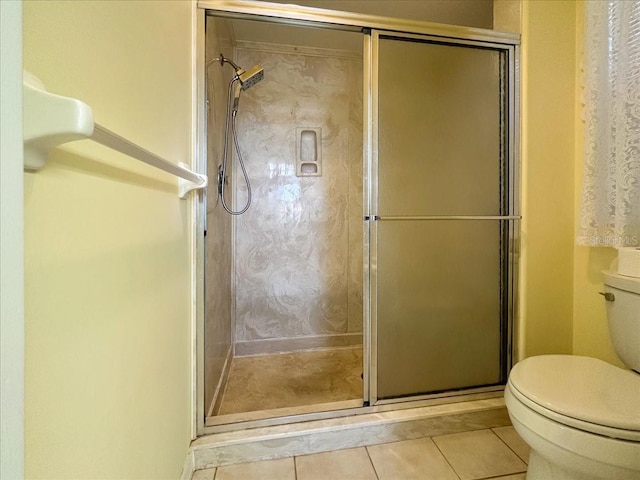 bathroom with tile patterned flooring, an enclosed shower, and toilet