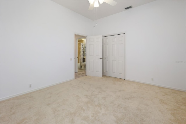 unfurnished bedroom featuring light colored carpet, a closet, and ceiling fan