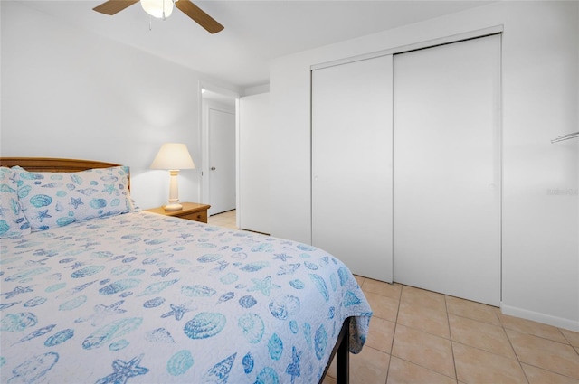 bedroom with light tile patterned floors, ceiling fan, and a closet