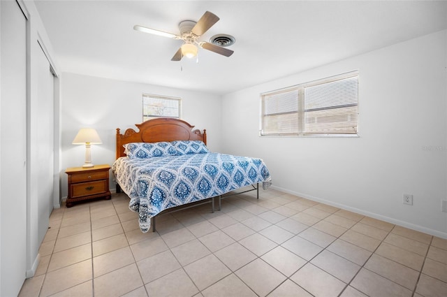 bedroom featuring light tile patterned flooring, ceiling fan, and a closet