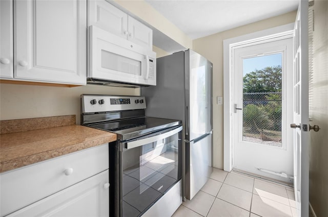 kitchen featuring white cabinetry, light tile patterned floors, and stainless steel electric range oven