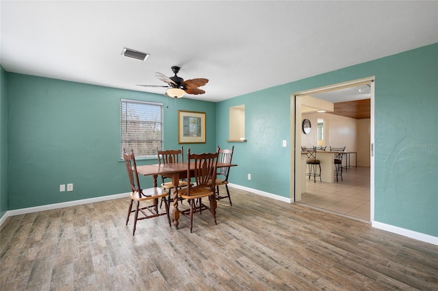 dining space with ceiling fan and light hardwood / wood-style flooring