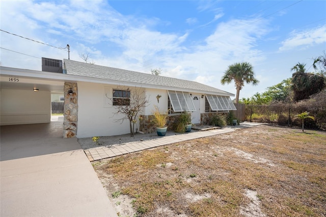 ranch-style house with a carport and cooling unit