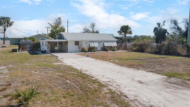 ranch-style home featuring a carport and a front lawn