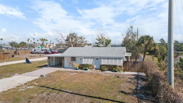 single story home featuring a carport and a front lawn