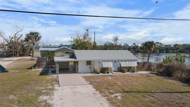 view of front of house with a water view, a carport, and a front yard