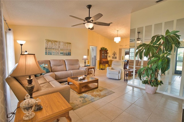 living room featuring light tile patterned flooring, vaulted ceiling, a textured ceiling, and ceiling fan