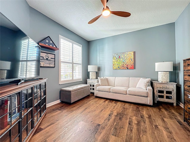 living room featuring hardwood / wood-style floors, a textured ceiling, and ceiling fan