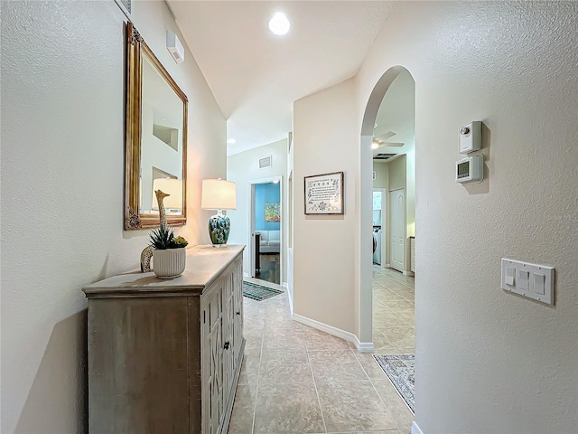 hallway with light tile patterned flooring and washer / dryer