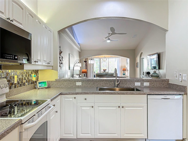 kitchen featuring sink, backsplash, white cabinets, ceiling fan, and white appliances