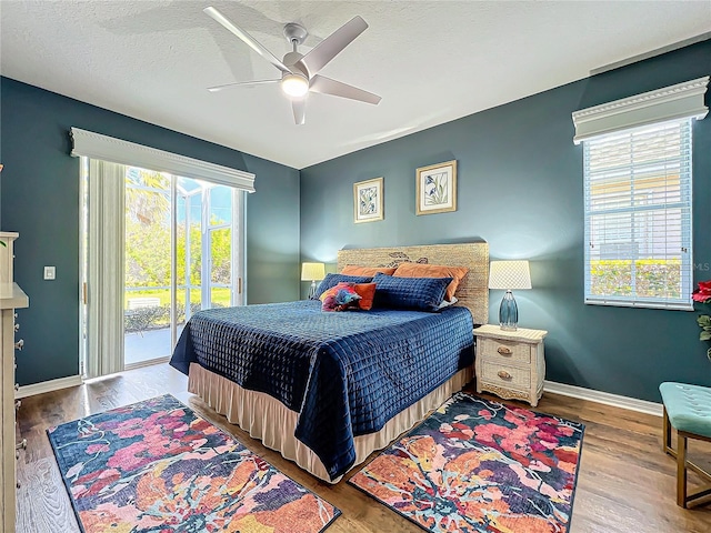 bedroom featuring access to exterior, wood-type flooring, a textured ceiling, and ceiling fan