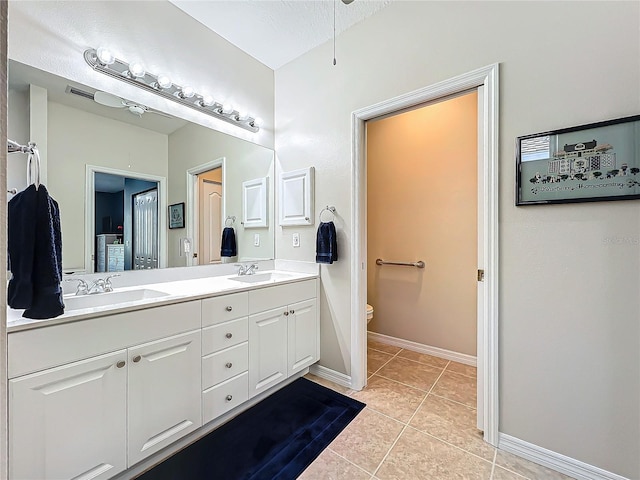 bathroom featuring vanity, tile patterned floors, and toilet