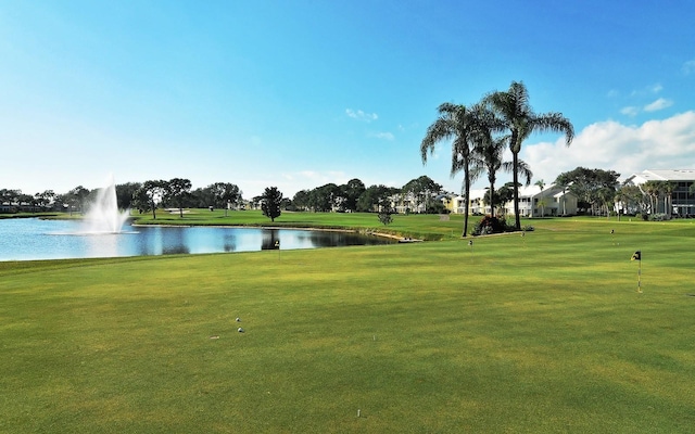 surrounding community featuring a water view and a lawn