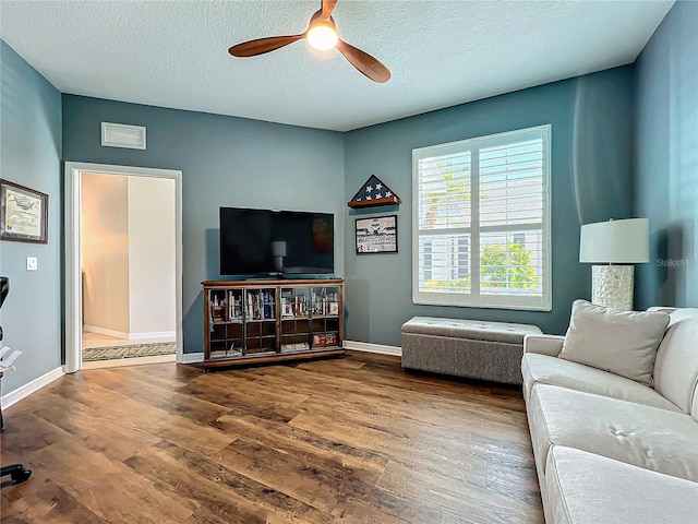 living room with hardwood / wood-style flooring, a textured ceiling, and ceiling fan