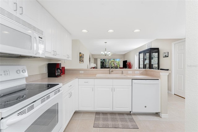 kitchen with white cabinetry, sink, hanging light fixtures, kitchen peninsula, and white appliances